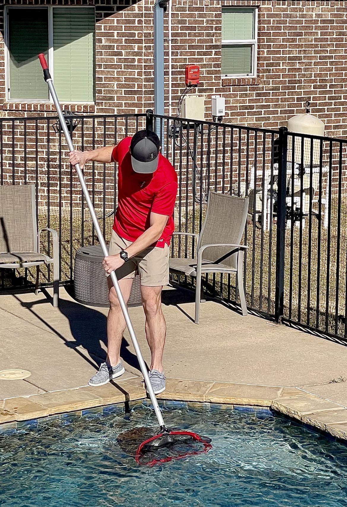 MD Pool Service professional technician cleaning a swimming pool with specialized equipment
